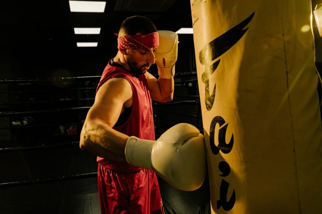 Boxer training intensely on a heavy bag in a dark gym for punching power article